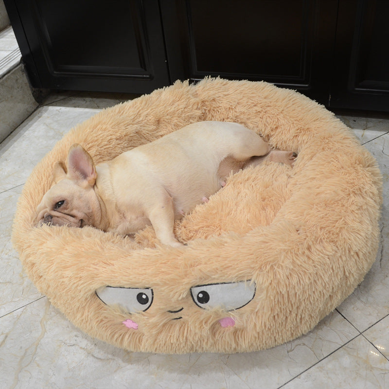 Beige plush round pet bed with an embroidered face and small dog resting inside