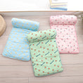 Cargar la imagen en la vista de la galería, Three folded cooling pet mats with pillow bolsters in pastel colors and cute fruit prints: blue banana, green avocado, and pink peach on wooden floor
