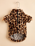 Load image into Gallery viewer, Plush leopard print dog jacket hanging on a wooden hanger showing front zipper and short sleeves
