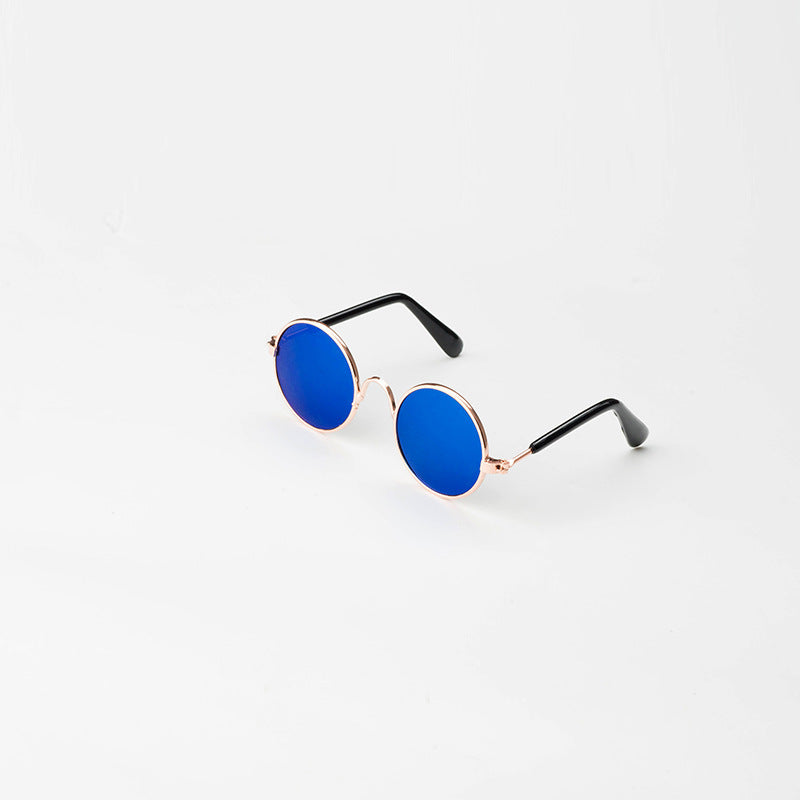 Pet sunglasses resting on soft surface showing lightweight rose gold frame  