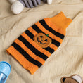Load image into Gallery viewer, Orange and black striped Halloween pumpkin dog sweater folded on beige fabric
