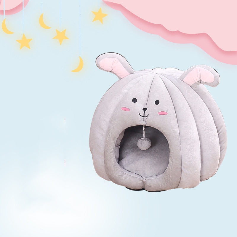 Light gray plush pet nest resembling a bunny with long ears and smiling face set against a soft dreamy background