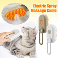 Cargar la imagen en la vista de la galería, Hand holding electric spray massage pet brush next to a gray tabby cat being brushed
