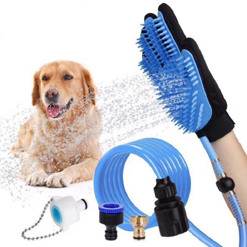 Black pet bathing glove with blue silicone brush, attached to blue hose and faucet adapters, spraying water on a golden retriever dog