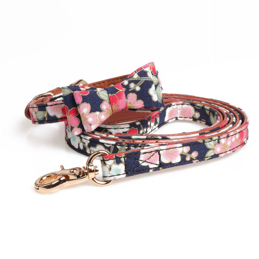 Close up of a floral patterned dog collar with attached leash and decorative bow tie
