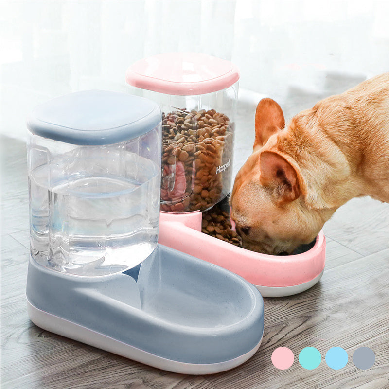 Dog drinking water from pink automatic pet feeder with clear food container