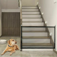 Cargar la imagen en la vista de la galería, Portable black mesh safety gate installed at bottom of indoor wooden staircase with a dog lying nearby
