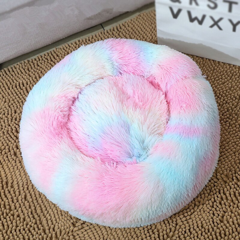 Top view of colorful pastel tie-dye round plush pet bed on rattan rug