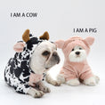 Cargar la imagen en la vista de la galería, Two dogs dressed in animal costumes side-by-side on white background, one in a cow costume and the other in a pink pig costume with text: 'I AM A COW' and 'I AM A PIG'
