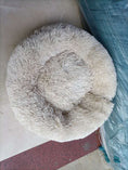 Load image into Gallery viewer, Beige plush round pet bed placed on floor with surrounding elements
