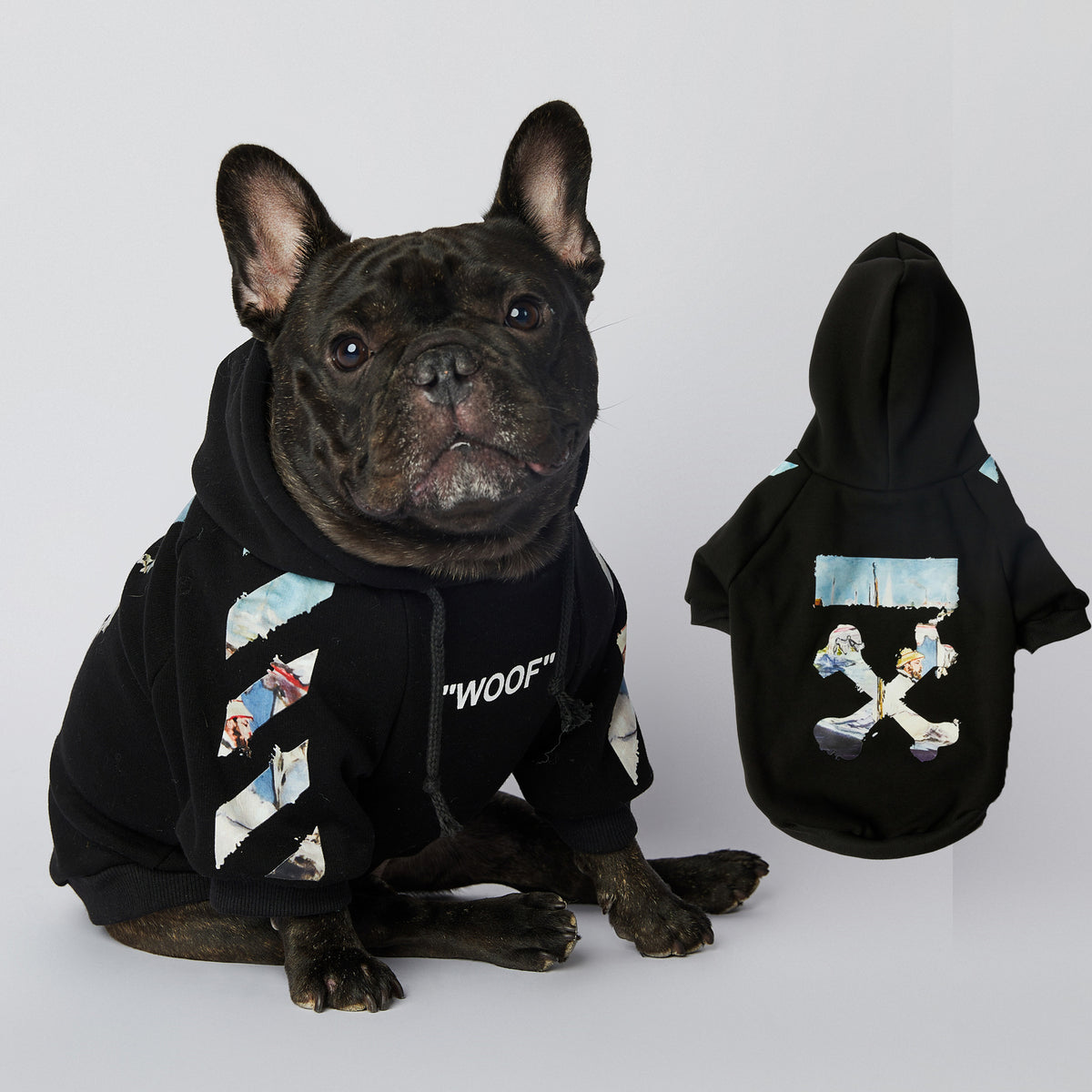 French bulldog wearing black artistic printed dog hoodie sitting next to matching displayed hoodie showing back design