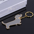 Load image into Gallery viewer, Dachshund keychain shown on black surface next to its silver gift box
