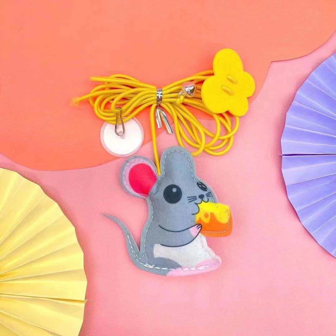 Felt mouse-shaped cat toy with yellow elastic rope and cheese piece on pink background
