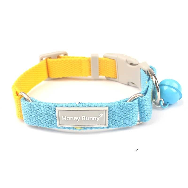 Close-up front view of blue and yellow woven dog collar with release buckle and blue bell