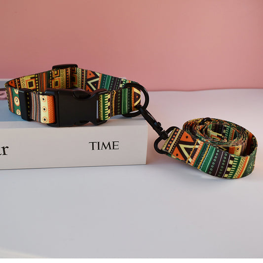 Green, orange, and black geometric patterned nylon dog collar and matching leash on white box with pink background