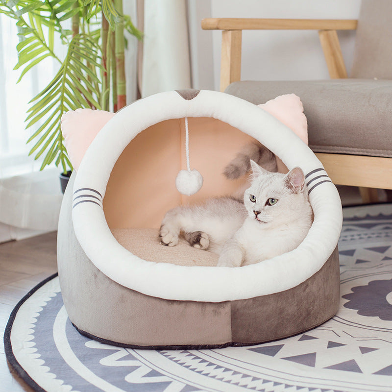Gray and white plush pet house with pink ears and a white cat resting inside