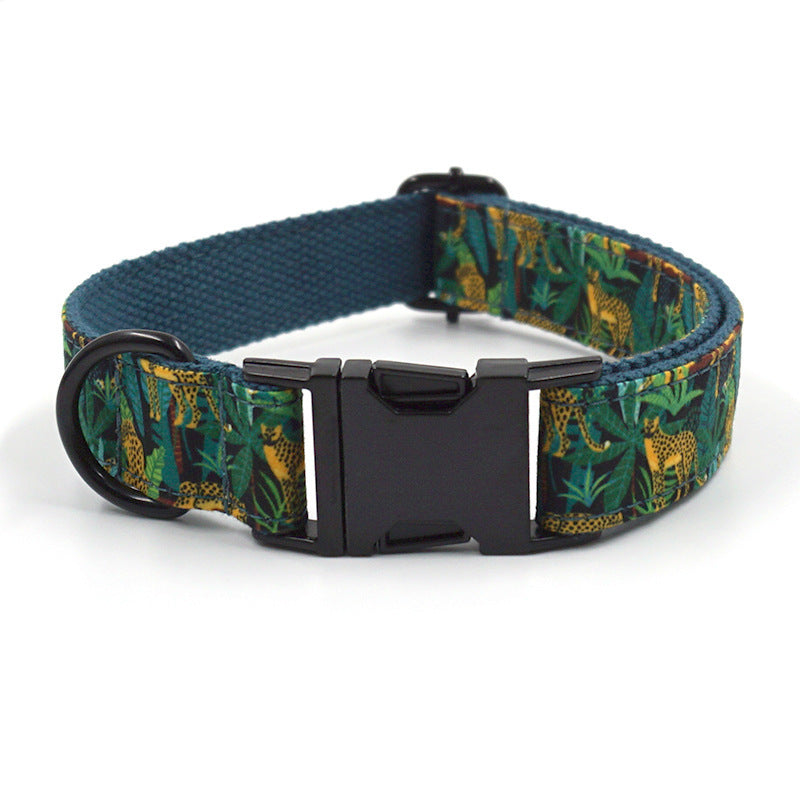 Close-up of adjustable green jungle print pet collar with black plastic buckle and D-ring