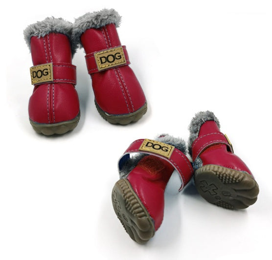 Red dog winter boots with gray faux fur lining and Velcro straps laid open