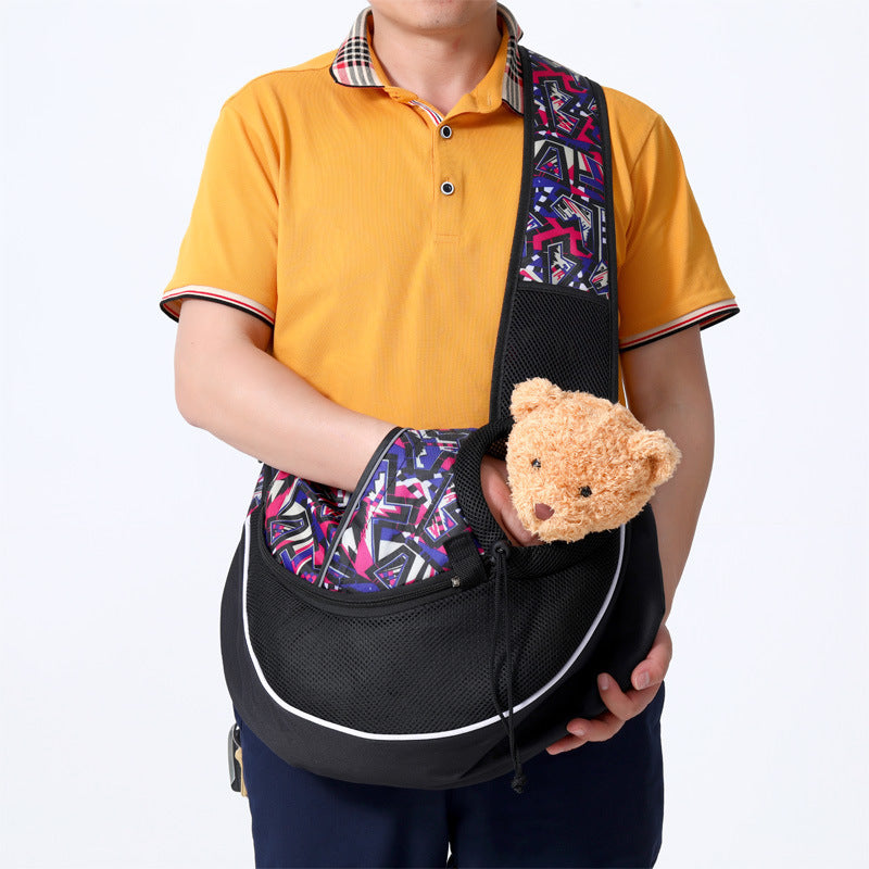 Man wearing purple and black patterned breathable pet sling carrier holding a plush teddy bear inside