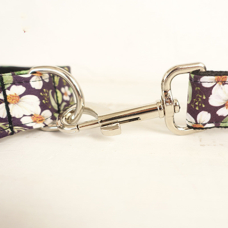Close-up of metal clasp attaching leash to collar with floral patterned fabric