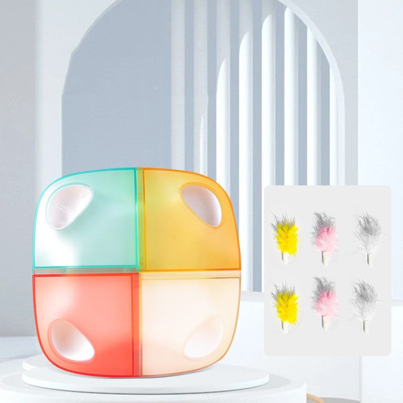 Colorful cube-shaped cat toy with four feather-filled compartments, displayed on white pedestal