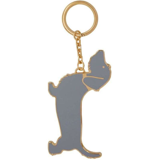 Close-up of metal dog keychain showing grey enamel and gold-tone finish against white background