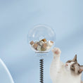 Load image into Gallery viewer, Cat reaching up to clear treat container on spring stem of interactive cat toy with treats inside
