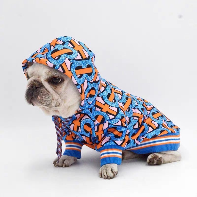 French Bulldog wearing a colorful graphic hoodie with a hood pulled over head