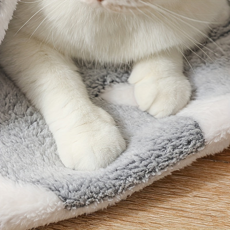 Close-up of cat paws resting on edge of gray fleece pet bed mat with white bones