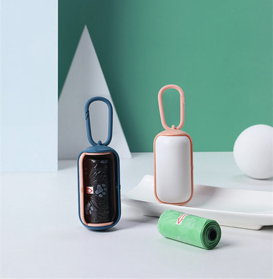 Two portable pet poop bag dispensers in pink-blue and white-pink with pet waste bags next to them