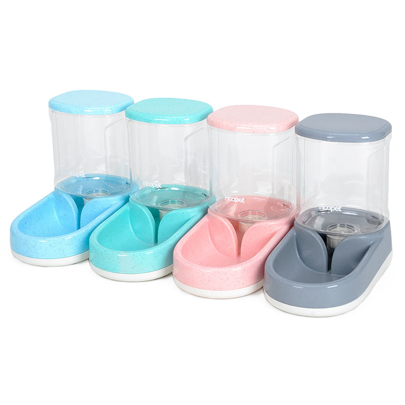 Four automatic pet feeders in blue, green, pink, and gray lined up side by side