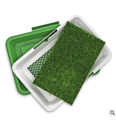 Dog potty training tray opened showing removable artificial grass and mesh tray inside