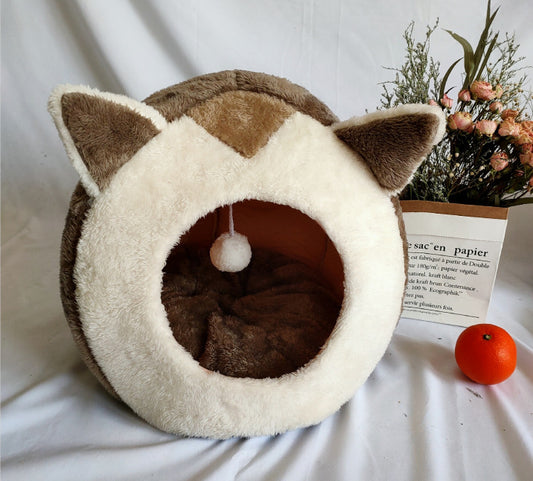 Brown and cream plush cat cave bed with fox-like ears and hanging pompom toy