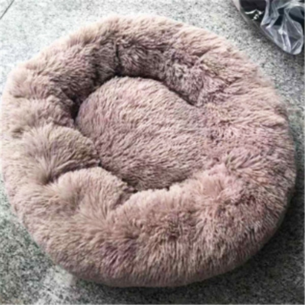 Brownish taupe fluffy round pet bed on a textured surface