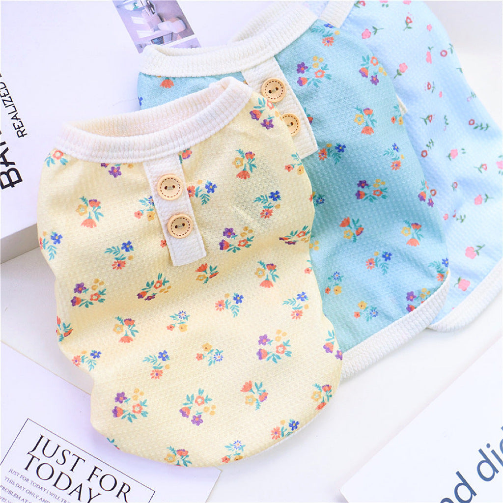 Yellow floral dog pajamas featuring mesh design laid next to blue version