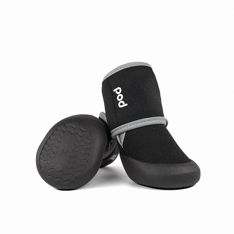Close up view of black neoprene and rubber outdoor dog boots showing soles and branding