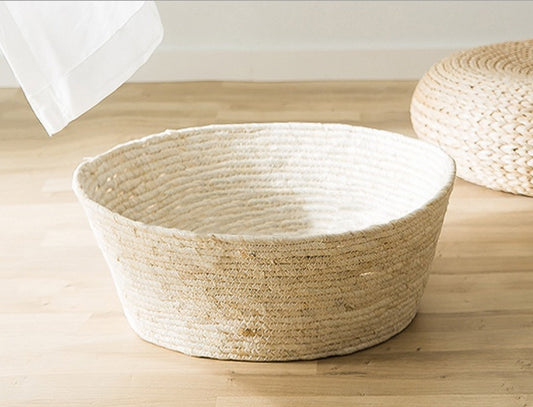 Empty handwoven rattan cat bed on wooden floor