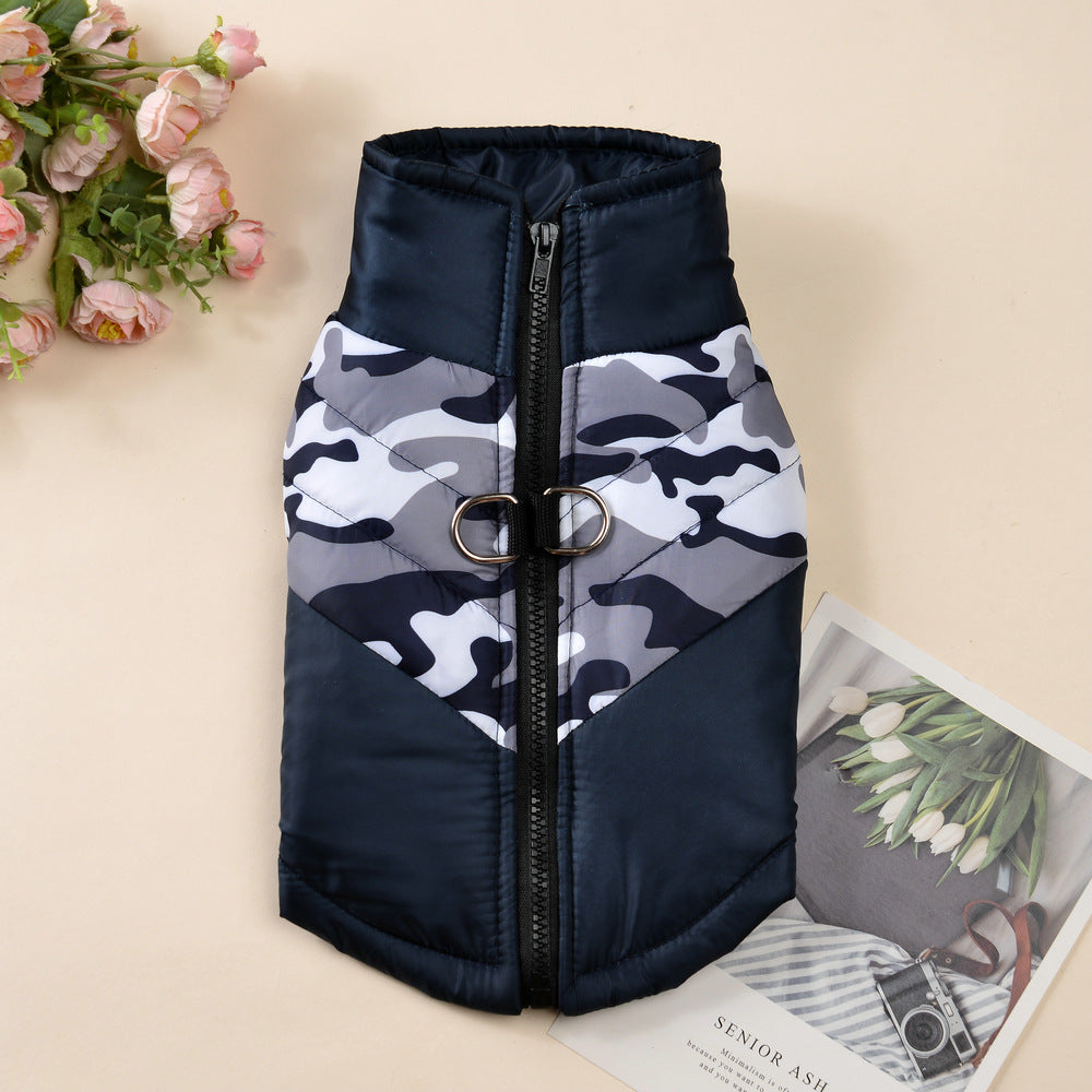 Black and white camouflage padded dog jacket with zipper and leash attachment on a flat surface
