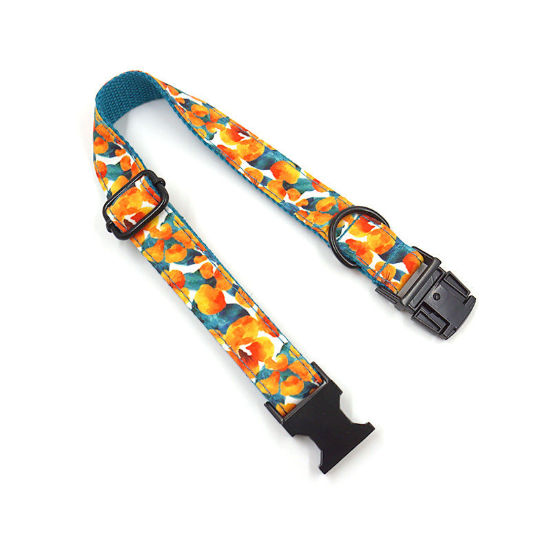 Close-up of adjustable tropical floral dog collar with black buckle and D-ring, vibrant orange and teal flowers