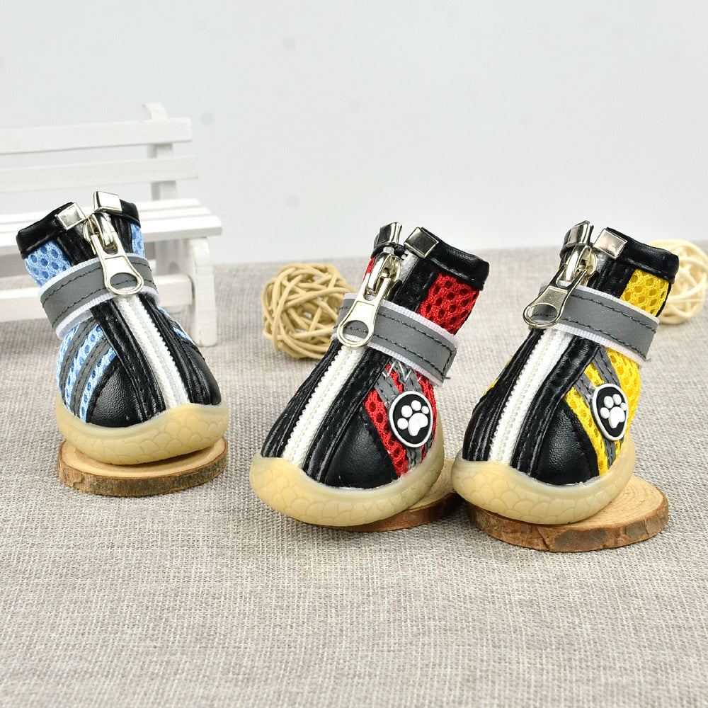 Close-up front angle of red, yellow, and blue breathable dog boots with zippered fronts and velcro straps