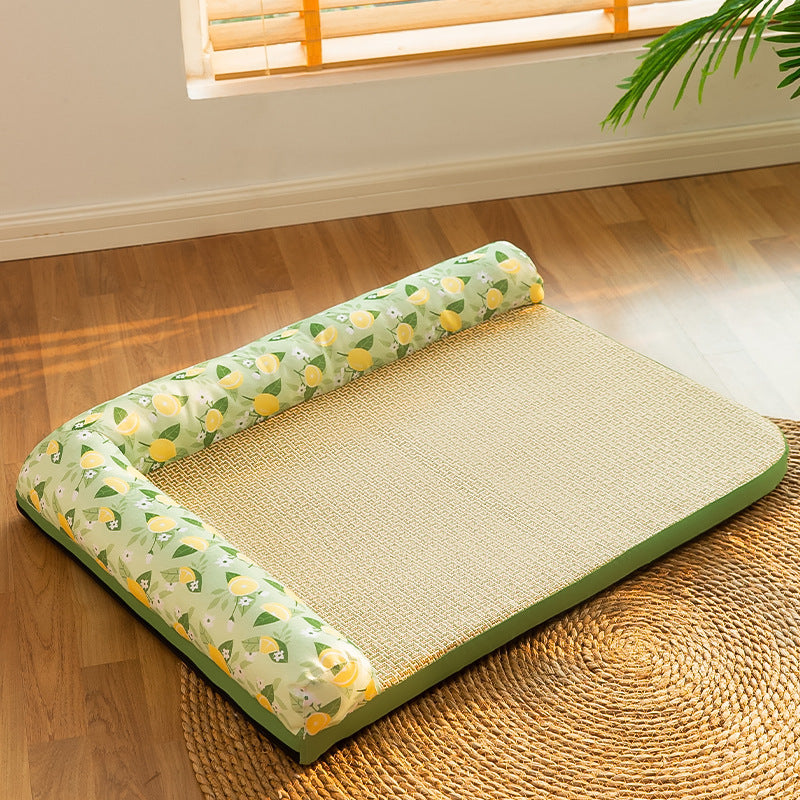 Empty cooling bolster pet bed with woven straw-like surface and lemon patterned bolsters placed on a round woven rug.