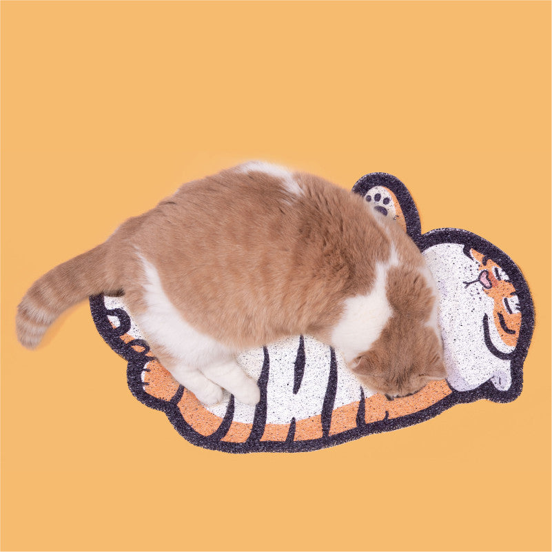 Cat lying down on fat tiger design litter mat on orange background