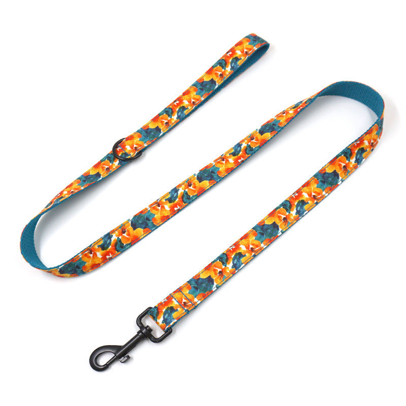 Full view of tropical floral dog leash laid flat with black clip and handle loop