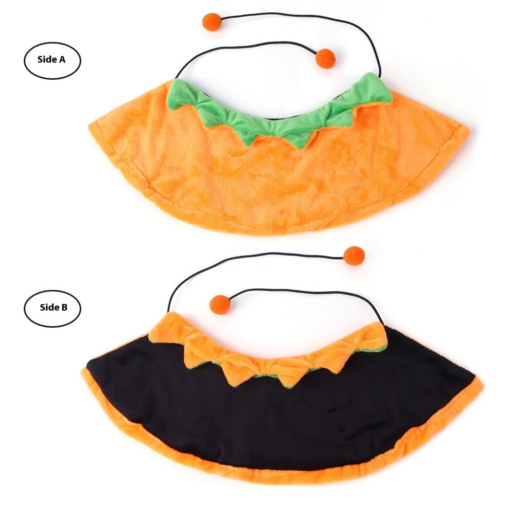 Two cloaks displayed flat with tie strings and pom-pom details; one shows front orange side with green collar, while the other shows reverse side in black and orange trim.
