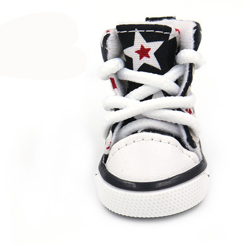 Close-up front view of a black and white star print dog shoe with white laces