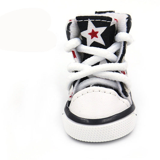 Close-up front view of a black and white star print dog shoe with white laces