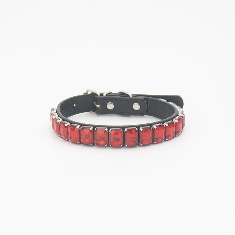 Close-up of bright red rhinestone PU pet collar laid flat on white background
