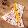 Charger l'image dans la visionneuse de la galerie, Flat lay of white blood splatter pet dress costume with yellow Do Not Enter sash on wooden floor with Halloween decor
