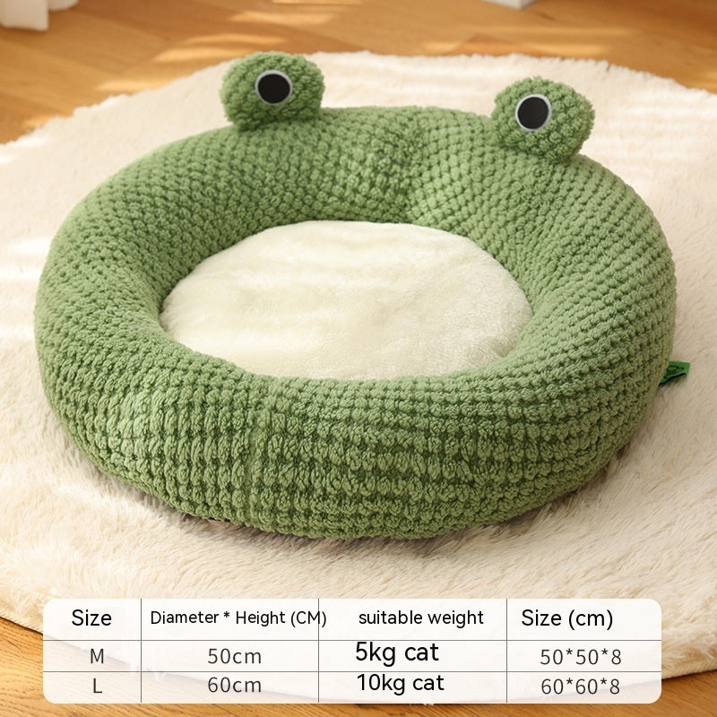 Green knitted frog pet bed with plush cream interior, showing size chart and a cat resting inside