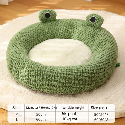Green knitted frog pet bed with plush cream interior, showing size chart and a cat resting inside